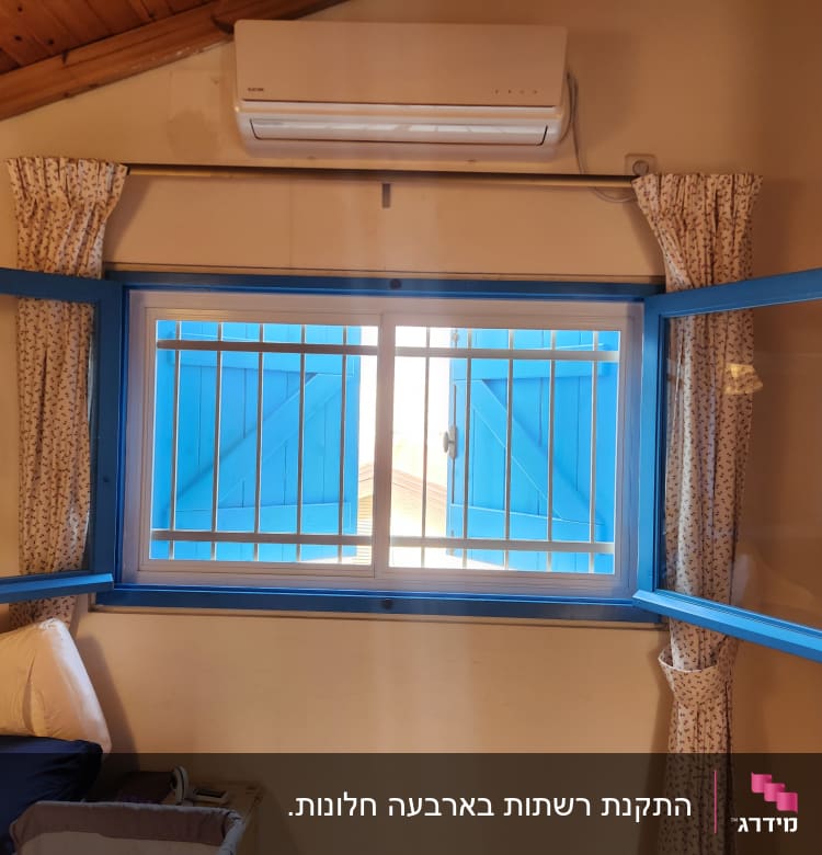 חלון עם מסגרת אלומיניום כחולה וסורגים